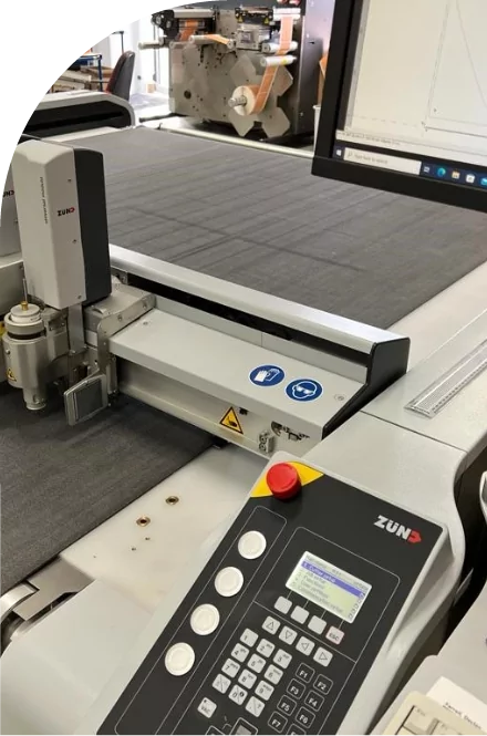 A machine is cutting a high quality piece of fabric in a factory.