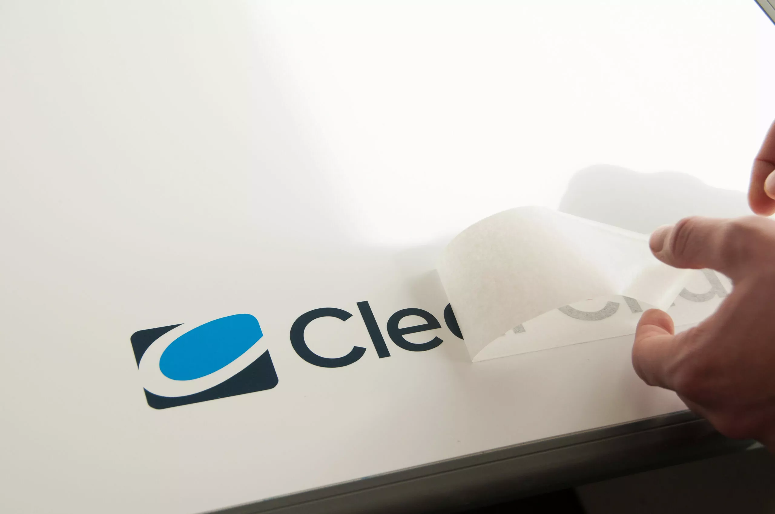 A person is applying labels on a white piece of paper.