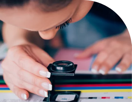 A woman using a magnifying glass to look at a custom label.