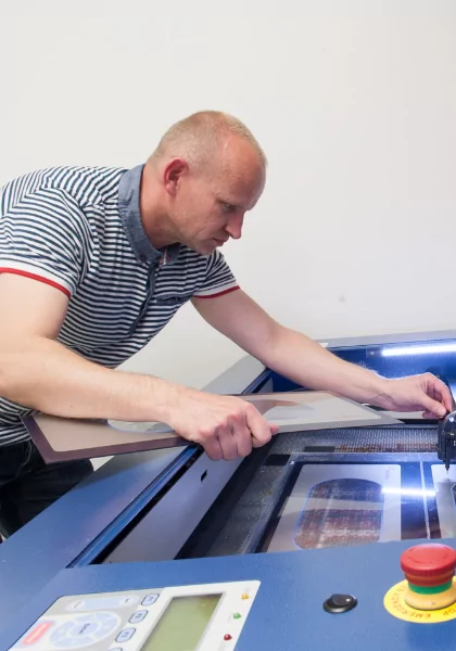 A man working on a laser cutting machine.
